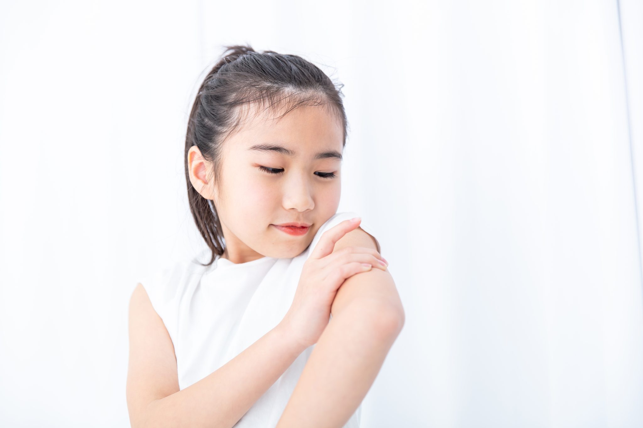 肩のお肌を見つめる女の子